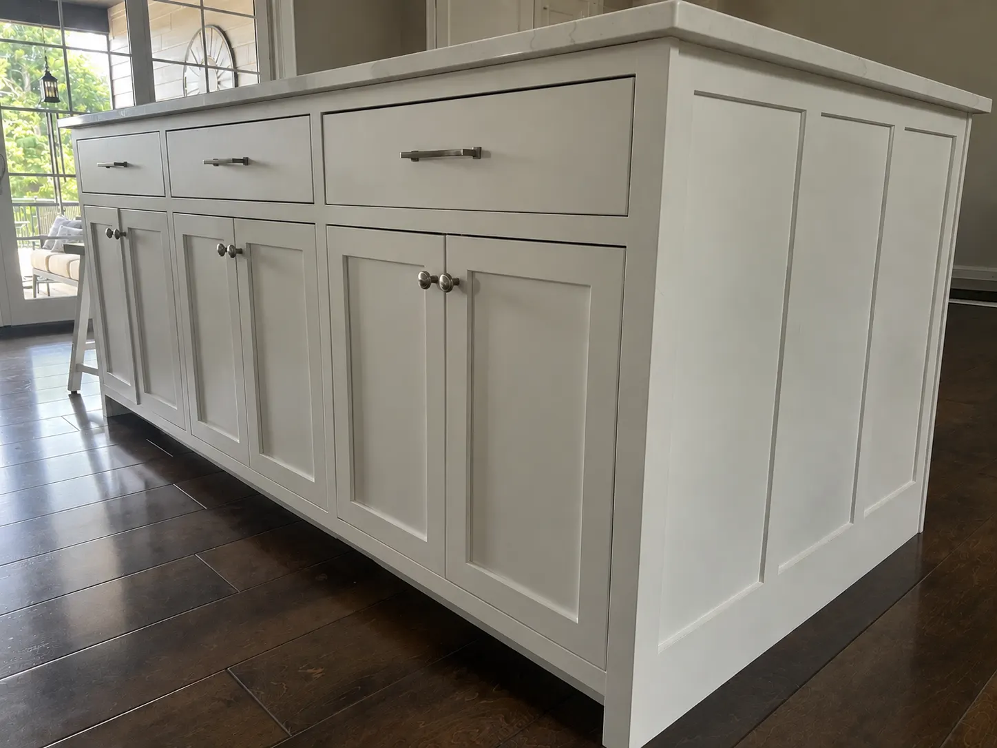 White paneled kitchen island with drawers and cabinet doors